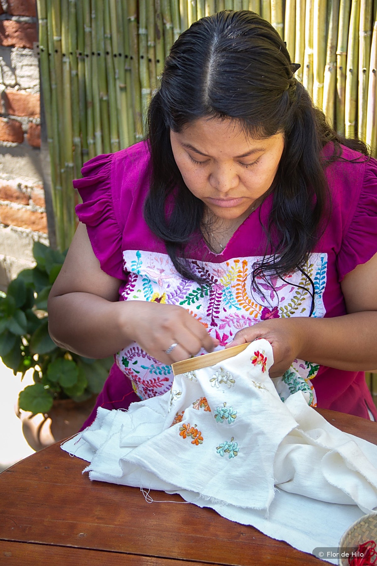 Andrea embroidering the heart earrings by hand